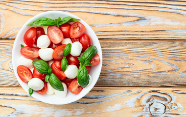 Basil leaves , cherry tomatoes and mozzarella cheese . In bowl food photography