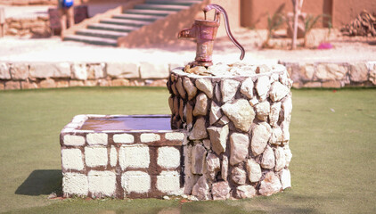 arabian rock hand pump water well in the park
