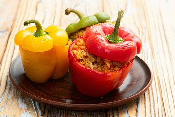 Baked stuffed pepper ( paprika ) with rice , carrot and meat . Top view on rustic background