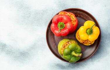 Baked stuffed pepper ( paprika ) with rice , carrot and meat . Top view on rustic background