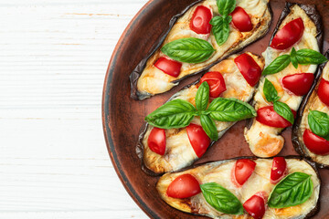 Italian mini pizza . Aubergine (eggplant ) with mozzarella cheese and basil . On rustic background