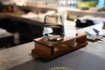 Finely crafted beverage cocktail and mocktail served in fine dining omakase restaurant. Drinks on table top. Dark dining environment.