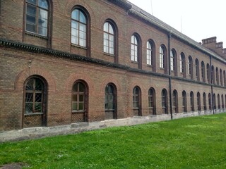 Obraz premium Old building on two floors brick wall grass in front expensive apartment with many windows horizontal