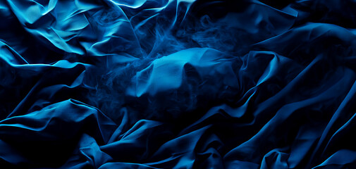 Silky blue fabric texture with smooth draping and subtle sheen on a dark background.