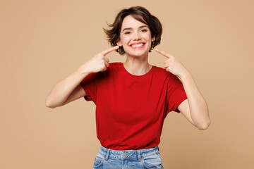 Young smiling happy satisfied woman she wear red t-shirt casual clothes point index finger on white...