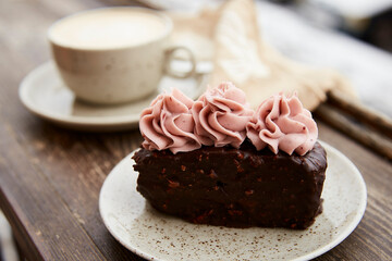Aestetics vegan brownie witn no sugar cake dessert and cup of cappuccino outdoor at the snowy day. Coffee with dessert winter aesthetics.