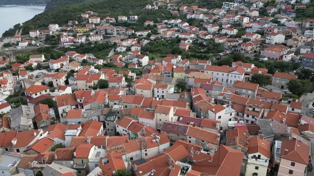 Video footage of Croatia, island Krk, Vrbnik. Aerial view of the roofs of houses, the Gothic Chapel of the Rosary, the Chapel of St. John in the Parish Church of the Assumption 