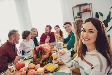 Photo of cheerful happy people relatives enjoying thanksgiving day sitting eating drinking indoors room home