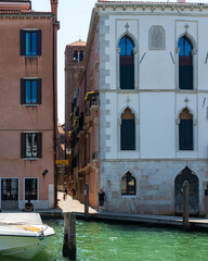 Ruelle entre des bâtiments anciens à Venise vue du grand canal par une journée ensoleillée.