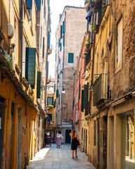 petite ruelle dans le cœur du quartier San Marco à Venise, avec des maisons traditionnelles, et des venitiens qui se promènent en été.