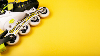 Stylish roller skates on yellow background, top view. Inline skates isolated on yellow, extreme sports background © Mariia
