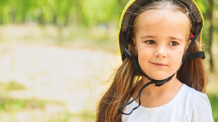 Girl skateboard with safety equipment - helmet, knee and elbow pads. Safe summer activity. Kids activity.