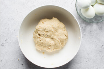 overhead view of dough for making nigerian egg roll in a white ceramic bowl, process of making nigerian egg roll and small chops
