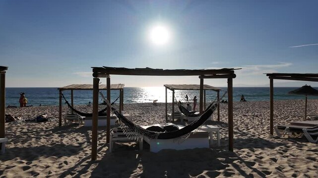 Beautiful beach scene in Comporta, Portugal on a bright summer vacation day, with clear blue skies, soft golden sand, and gentle ocean waves. 