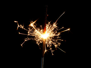A single sparkler glowing in the dark for New Year&rsquo;s.


