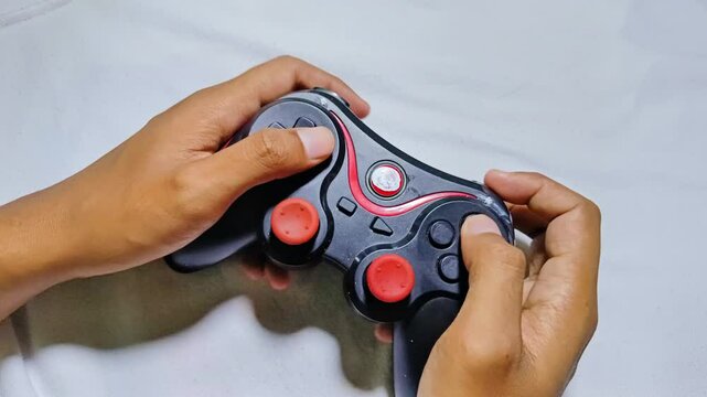 man playing a black game console joystick enthusiastically, on a white background. gamers play console games with game sticks