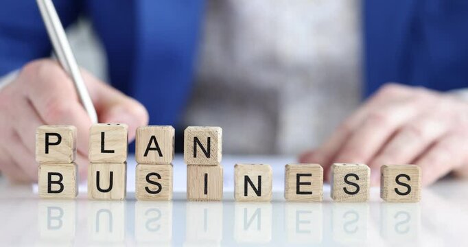 Written business plan, block of wooden cubes close up, shallow focus. Executive summary, business concept