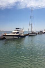 Fototapeta premium Boats anchored at a calm marina under a clear blue sky.
