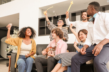 A group of multiracial teenagers is playing guitar and singing a song together while happily having fun blowing bubbles at the afternoon party. Recreational activity and celebration concepts.