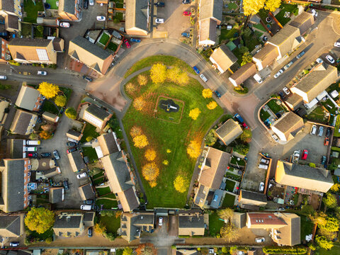 Drone top down view of a recently built affordable and private housing development in Britain. A communal green space is seen in the centre.