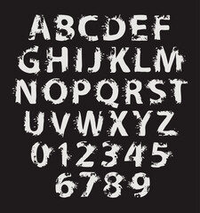 grunge lettering in abstract letters with spots and drips. Vector set of alphabet letters written in white paint on black background. Spattered font