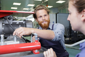 engineer showing machinery to female trainee