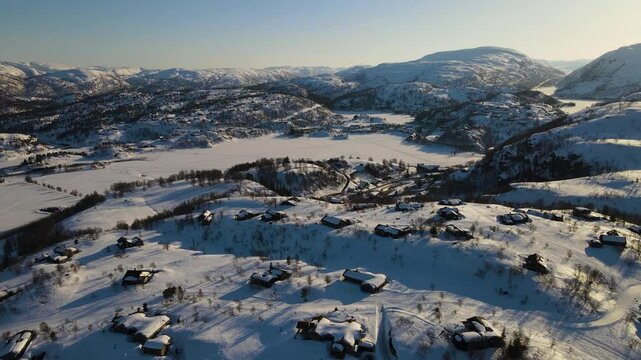 Aerial Drone Shot of Snow-Covered Winter Mountains and Cabins in Sinnes, Sirdal, Agder, Norway