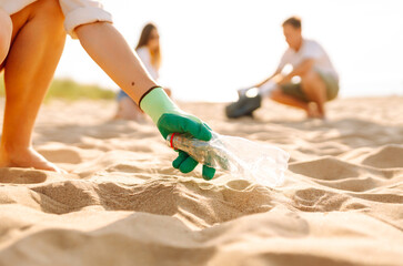 Groups of volunteers actively participate in a beach cleanup, collecting trash from the sand while enjoying the beautiful sunny afternoon, fostering community spirit and environmental responsibility. 