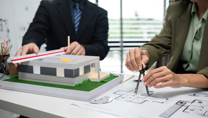 Businessmen Collaborating on Real Estate Project with Architectural Model and Blueprints in Modern Office