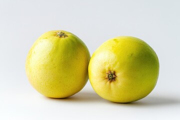 Fototapeta premium A perfectly ripe yellow guava fruit with a stalk and several leaves, standing on a white background