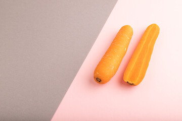 Orange Carrot on gray and pink pastel paper, Side view, copy space