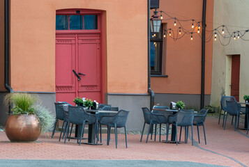 chairs and small tables in a street outdoors cafe in the town Cesis,Latvia.