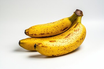 Photo of several perfectly ripe banana seeds in a bunch isolated on a white background, highlighting the bright yellow color and smooth skin texture and spots