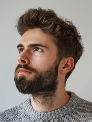 Obraz premium Man looking down, thoughtful expression, neutral color palette, portrait photography style.