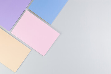 Top view of pink, purple, blue and beige notebooks on grey background. School, office wallpaper. Flat lay, copy space.	