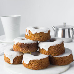 Iced mini bundt cakes on a white plate, vanilla bundlette on a plate, small vanilla bundt cakes with an icing glaze