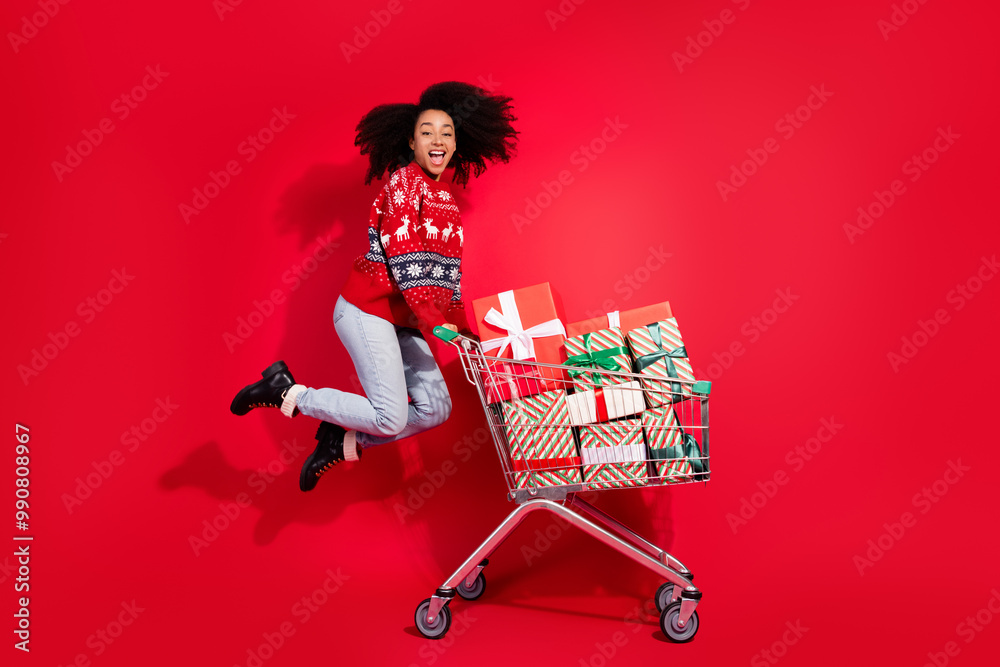 Sticker Full body photo of attractive young woman jump push shopping gift cart dressed christmas clothes theme party on red color background