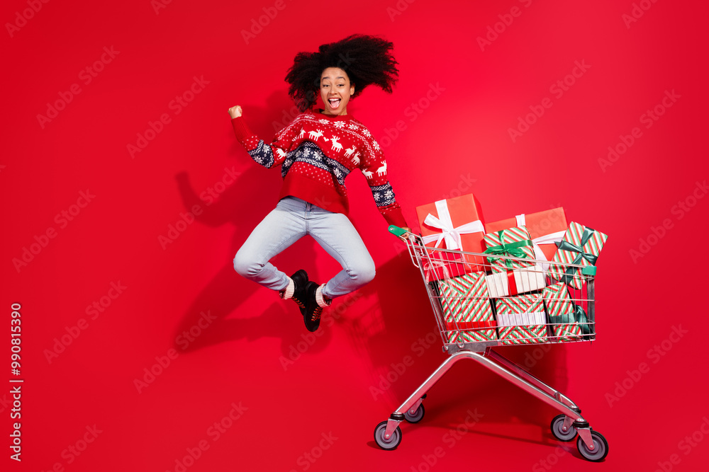 Canvas Prints Full length photo of lucky positive girl wear print sweater jumping choosing xmas gifts empty space isolated red color background