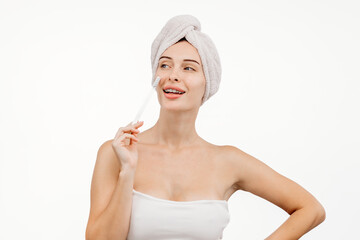 The concept of beauty and personal hygiene. An attractive, happy young woman in a bath towel holds a toothbrush. This image embodies self-care and the joy of daily routines.