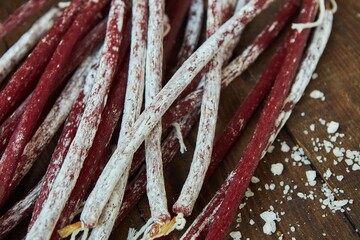 Dried hunting sausages lie on a wooden surface. Meat production.
