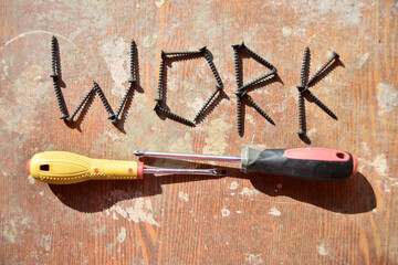 word work made of screws and two screwdravers below