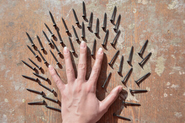 conceptual photo of the female hand surronded ith screws