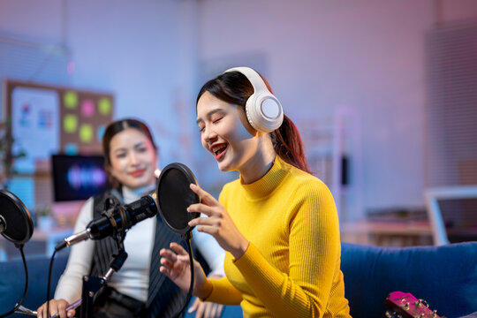 Two asian women recording podcast from home studio
