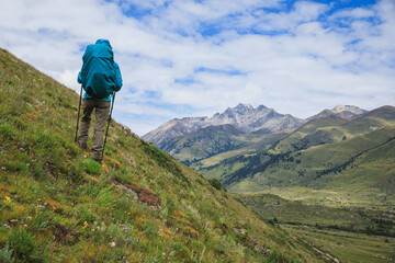 Woman backpacker hiking on high altitude mountains top