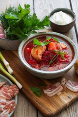 National dish of Ukrainian cuisine borscht with vegetables, turkey meat, herbs, sour cream and traditional bread (bun with garlic and dill, pampushka) with bacon (pork). Cultural heritage.