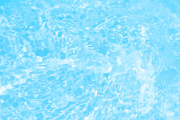 Blue water with ripples on the surface. Defocus blurred transparent blue colored clear calm water surface texture with splashes and bubbles. Water waves with shining pattern texture background.