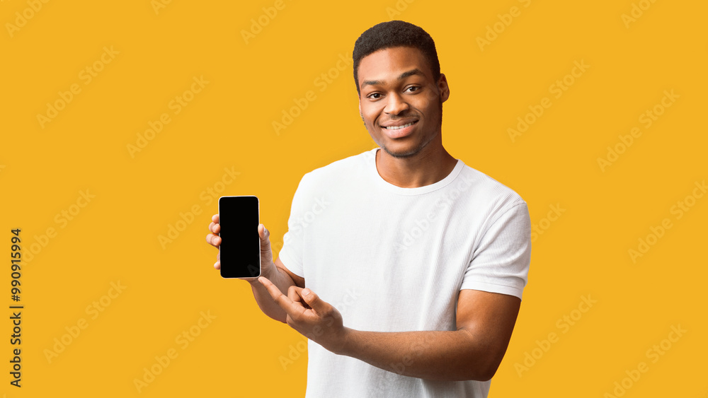 Poster useful app or website. black man pointing at blank cell phone screen for advertising text, empty spa