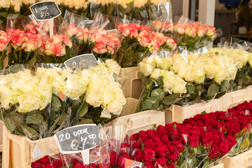 White, red and yellow roses offered at the Haagse market in The Hague, Netherlands. Bouquets of flowers in a row.