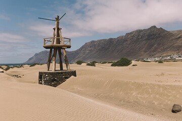 Molino de madera con risco de Famara de fondo
