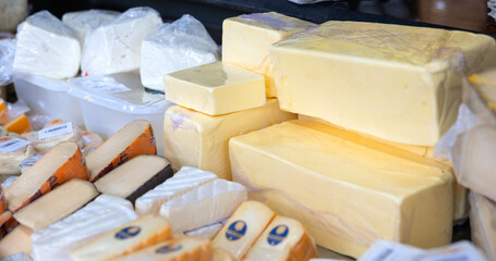 Various types of cheese on sale at a market stall. Haagse Market in The Hague, Netherlands. Dairy products, cottage and goat's cheese, Brie, Camembert.